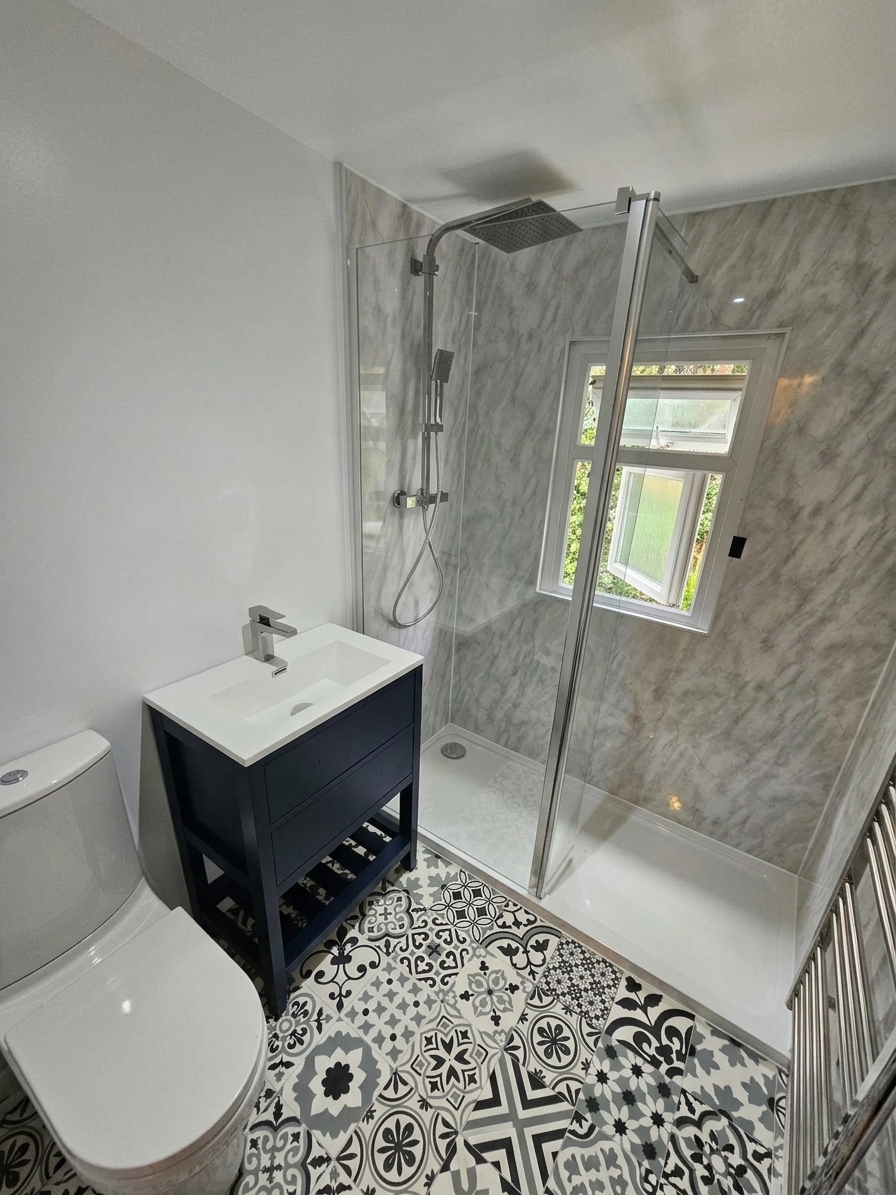 Bathroom with a walk-in shower, navy vanity unit and patterned floor tiles